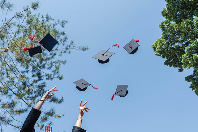 Graduation diplomas being thrown in the air