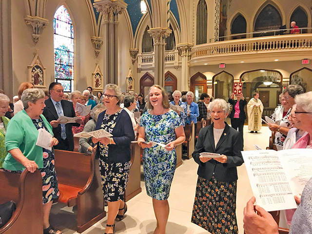 Sister Colleen Gibson, S.S.J. (center) is surrounded by her community during her final vows ceremony. 