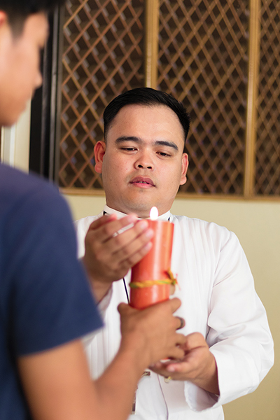 Brother Joel C. Añasco, S.C. lights a candle