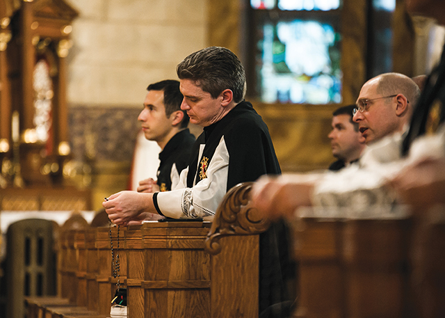 Brother Nathaniel Pierce, S.J.C. prays the Rosary with community members.