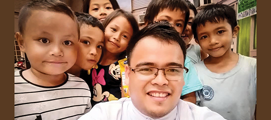Brother Joel C. Añasco, S.C., with some of the low-income children his community serves in the Philippines.